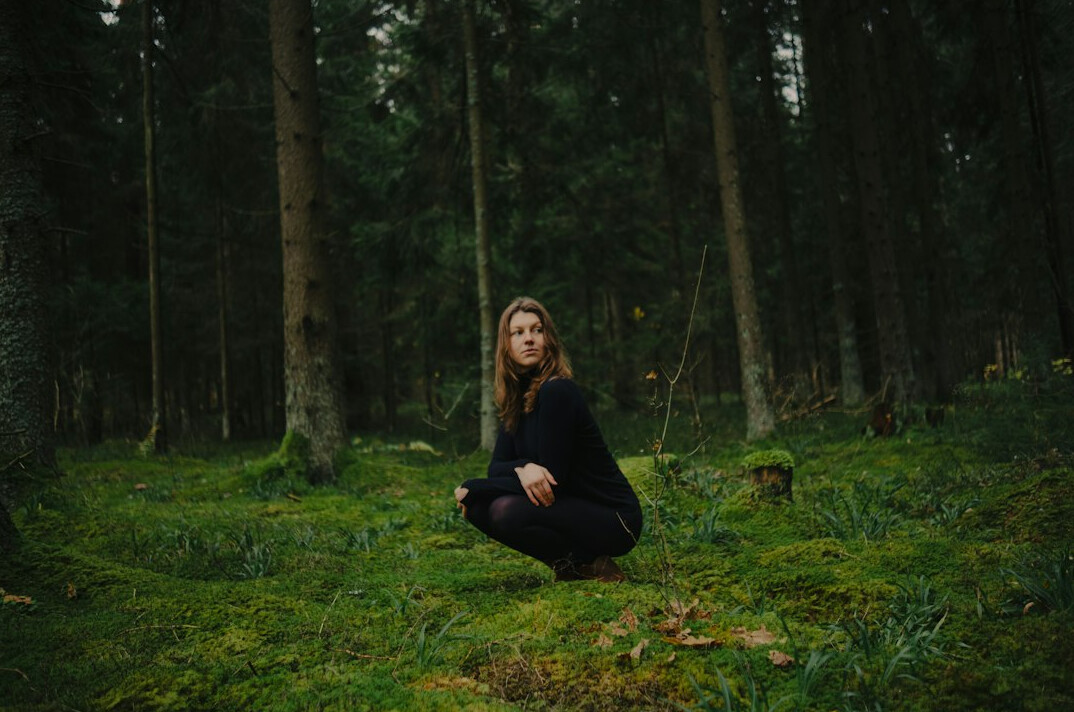 woman meditating in forest